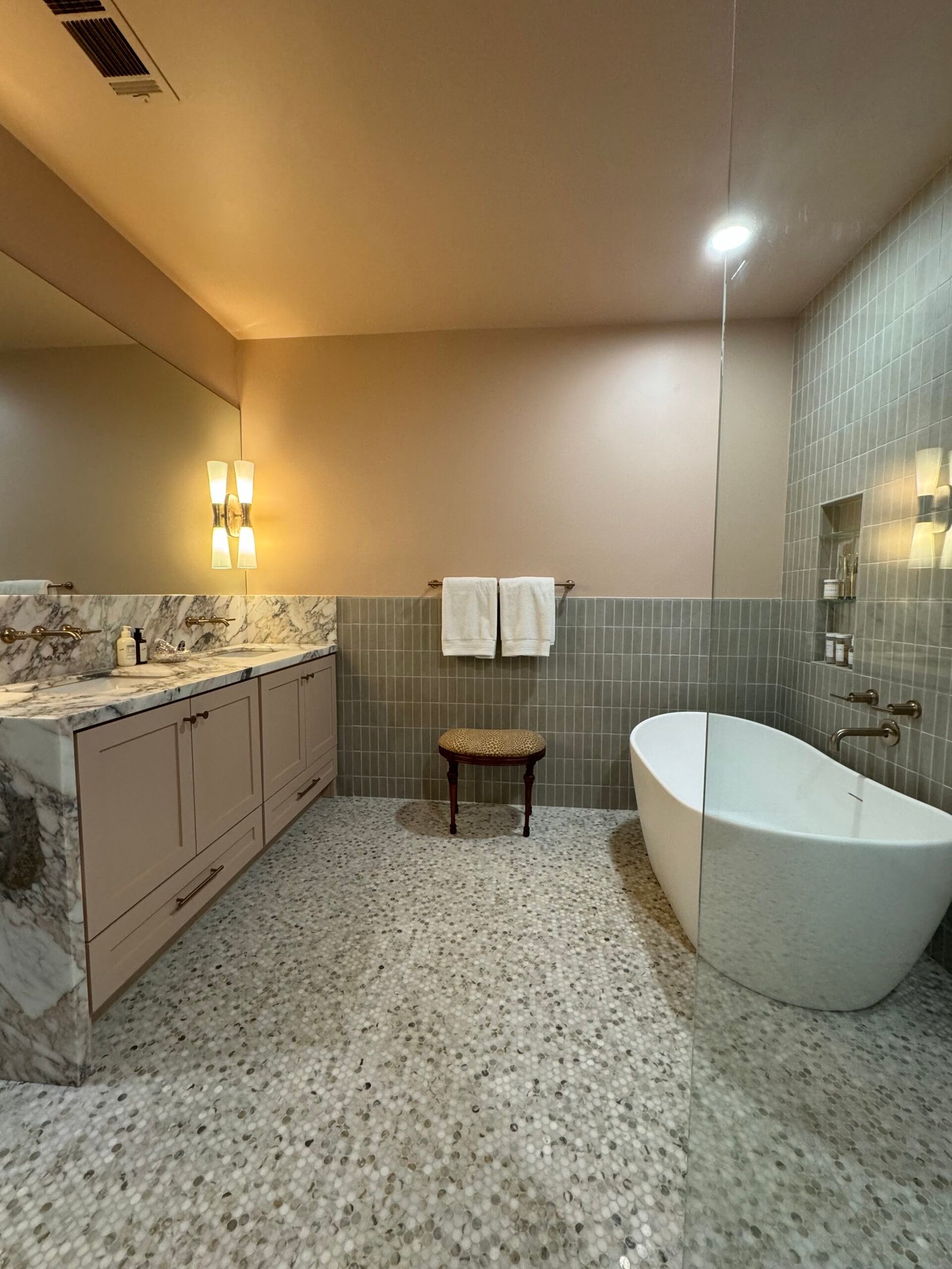 Bath with freestanding tub, marble vanity and tiled wainscot