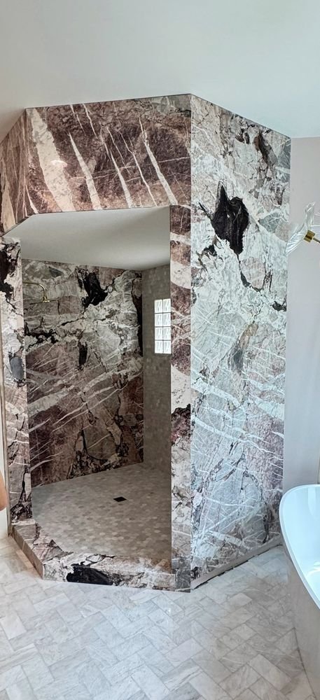Veined stone shower enclosure during construction